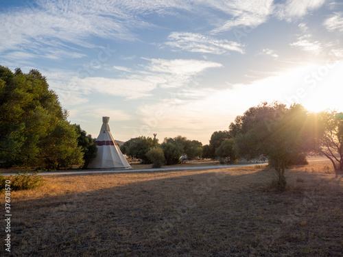 Caseta de campa  a de estilo tipi indio en un bosque durante la puesta de sol