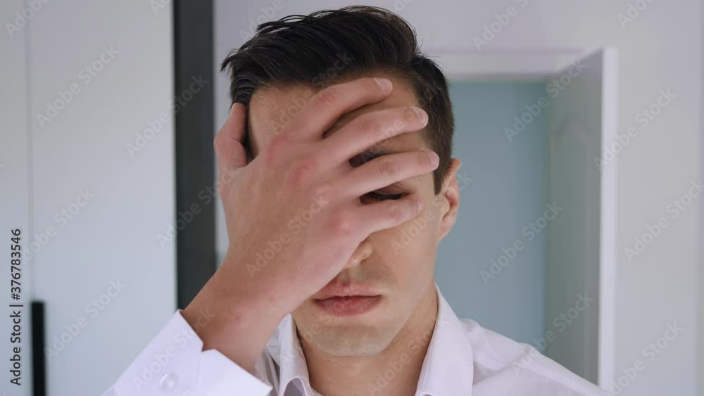 Portrait of attractive man making facepalming pose with hand. Showing an expression of dismay, exasperation, embarrassment. Businessman is disappointed and covers his face with his hand. Portrait of attractive man making facepalming pose with hand. Showing an expression of dismay, exasperation, embarrassment. Businessman is disappointed and covers his face with his hand.