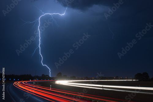 Light trail against lightning at night