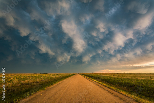 View of thunderstorm over rural dirt road in Kansas photo