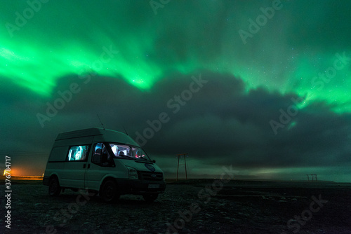 View of car parked on landscape under Aurora Borealis