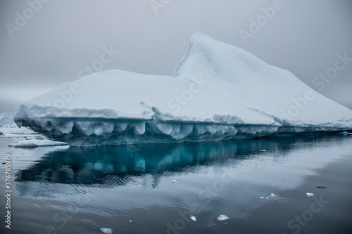 Iceberg drifting on frigid water coast of Booth Island in Antarctic Peninsula