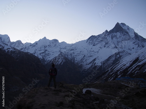 A climber standing in front of a snow-covered rock in the early morning, ABC (Annapurna Base Camp) Trek, Annapurna, Nepal © Mithrax
