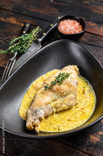 Stew with rabbit legs with rosemary and garlic. Wooden background. Top view