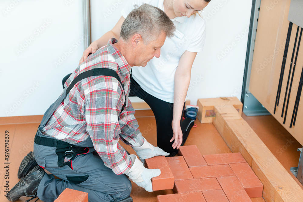 Fotografie Worker in occupational therapy re-learning to lay bricks