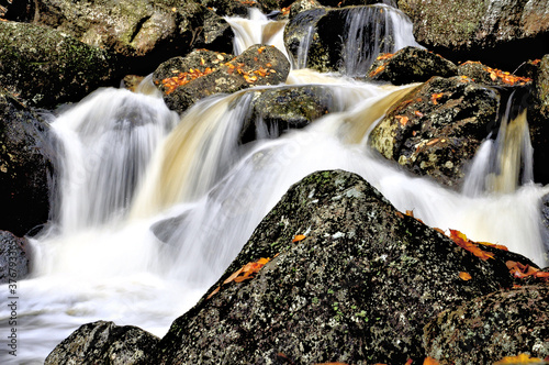 Fast-flowing stream plunging through rugged bed of granite bounders, Harvard Brook, White Mountains, New Hampshire. photo