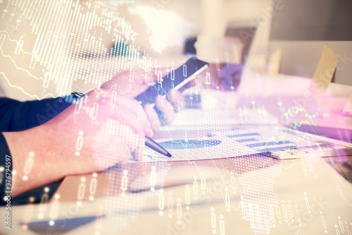 Double exposure of man's hands holding and using a phone and financial graph drawing. Analysis concept. © peshkova