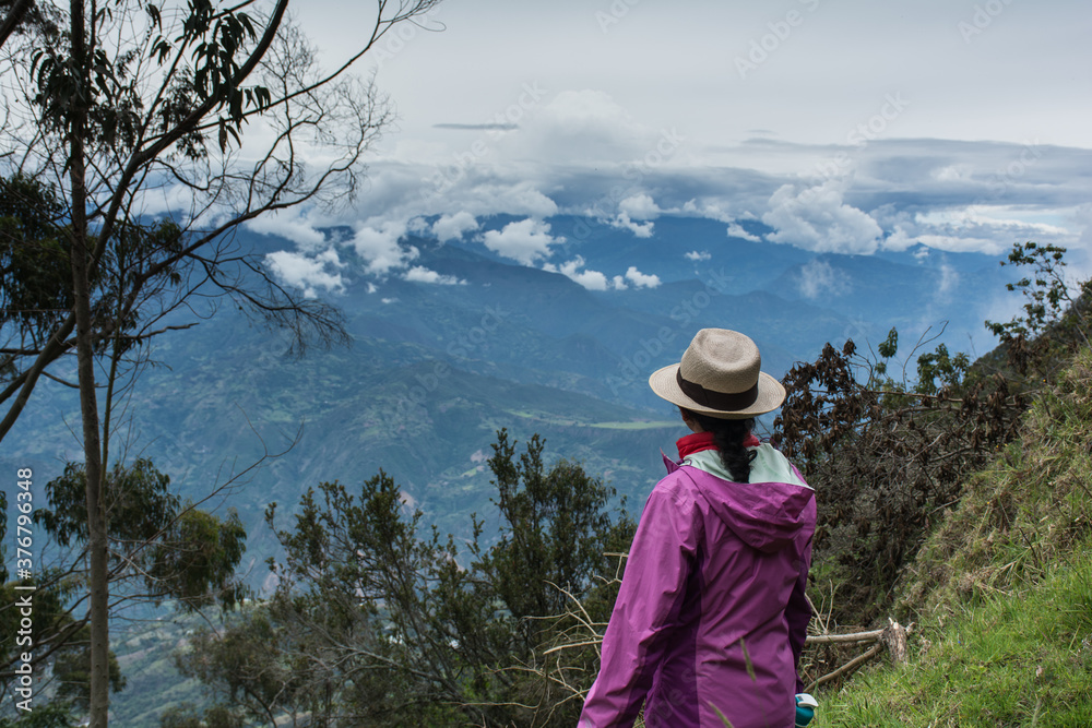 woman admiring mountainous and cloudy landscape