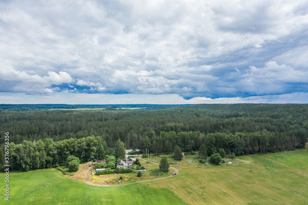 Aerial view of a farm with red roofs in a field with green grass