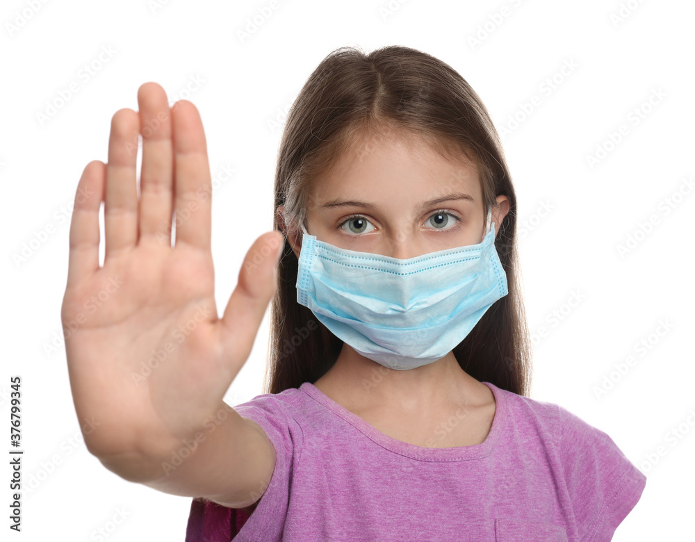 Little girl in protective mask showing stop gesture on white background. Prevent spreading of coronavirus Little girl in protective mask showing stop gesture on white background. Prevent spreading of coronavirus