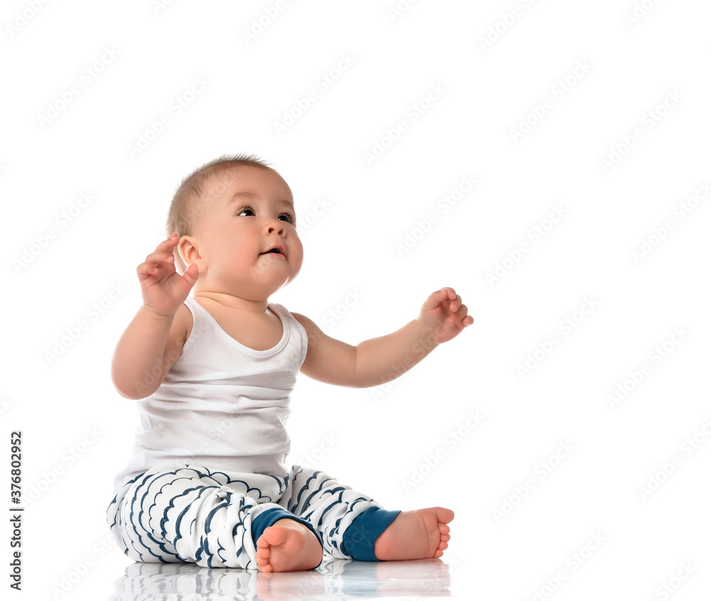 Cute plump baby boy in looking up sitting on floor Cute plump baby boy in looking up sitting on floor
