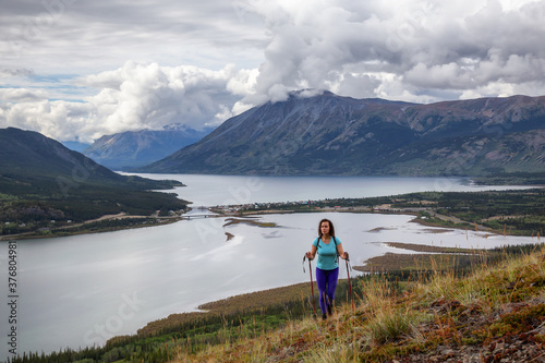 Adventurous Girl Hiking up the Nares Mountain during a cloudy and sunny evening. Taken at Carcross, near Whitehorse, Yukon, Canada. © edb3_16