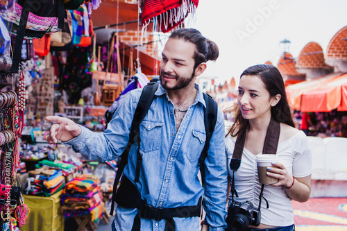 Latin couple backpacker shopping in a Tourist Market in Mexico City, Mexican Traveler in Latin America