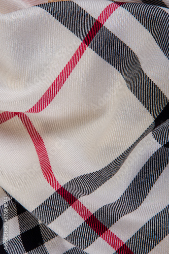 top view closeup crumpled milky checked scarf with black, white and red strips