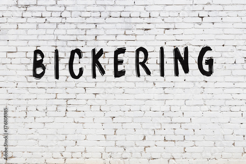 Bild auf Leinwand White wall with black paint inscription bickering on it