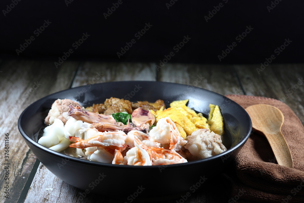 Traditional oriental and special porridge with boiled topping meat, boiled fresh peeled shrimp, chopped fried egg, steamed squid and roasted pork in the bowl. Famous street food breakfast menu. Traditional oriental and special porridge with boiled topping meat, boiled fresh peeled shrimp, chopped fried egg, steamed squid and roasted pork in the bowl. Famous street food breakfast menu.