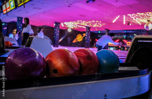 Bowling Balls inside a dark, neon lit bowling alley