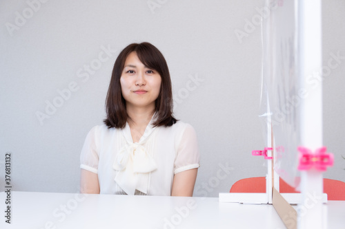 飛沫対策されたテーブルと女性