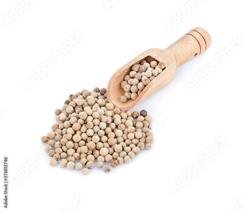 White peppercorns in a wooden spoon, isolated on white background.