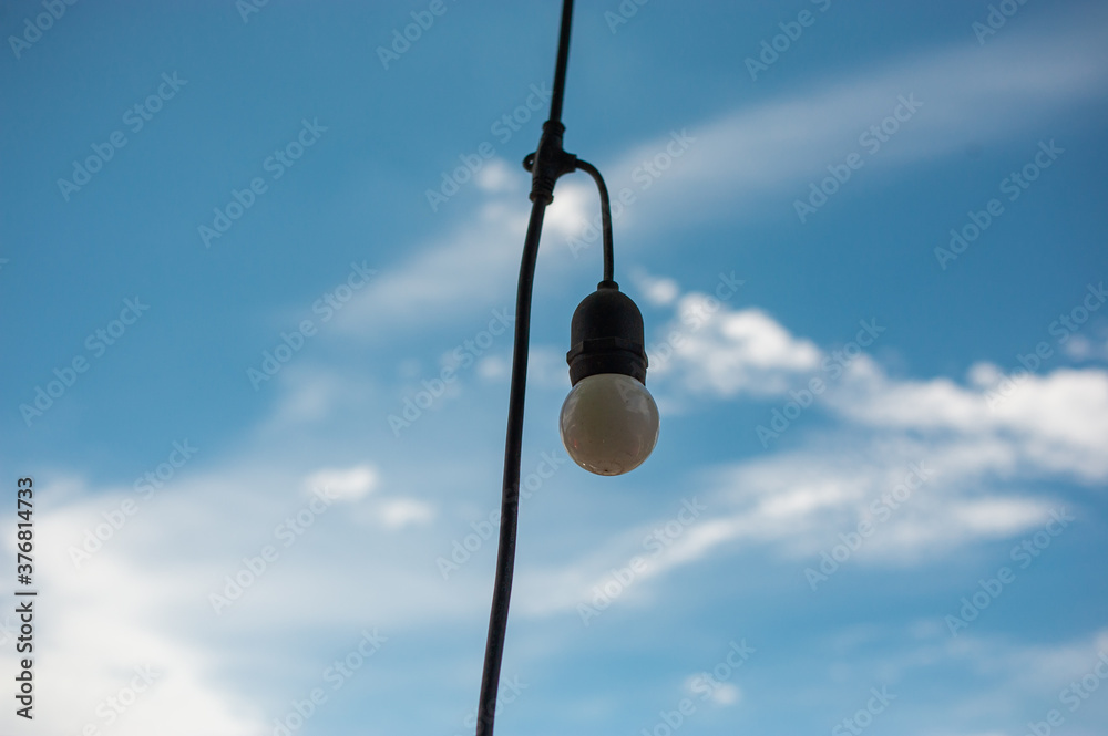 Old light bulbs hanging on electric wires, sky and cloud background. Old light bulbs hanging on electric wires, sky and cloud background.