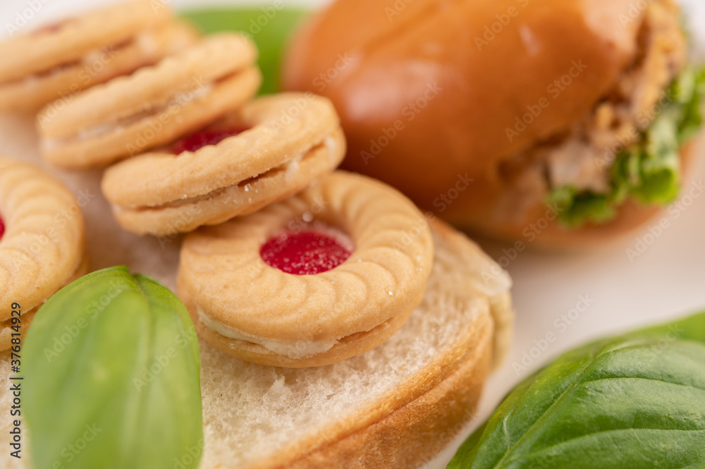 Bread slices, stuffed buns, and burgers on a white plate. Bread slices, stuffed buns, and burgers on a white plate.