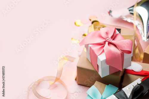 Holiday Luxury stylish gift present box tied with pink bow on pink background, decorated with confetti. Birthday, Christmas, New Year, Mother day, sale concept, copy space, banner