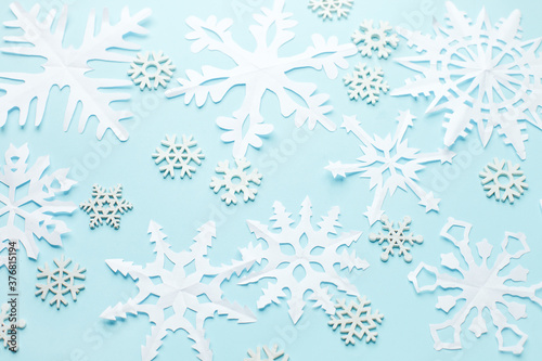 Children's paper snowflakes cutouts on blue background, tender winter holiday background, copy space, banner, flyer, coupon, creative easy diy idea for seasonal papercraft