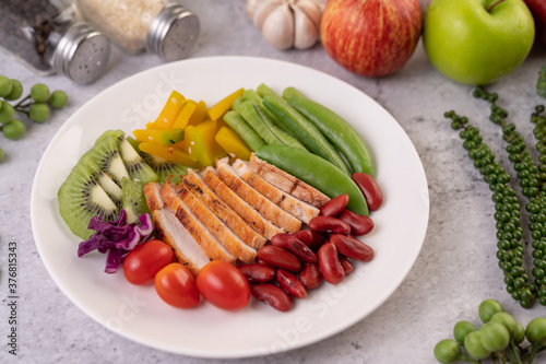 Sliced ​​chicken steak with peas, tomatoes, kiwi and pumpkin.