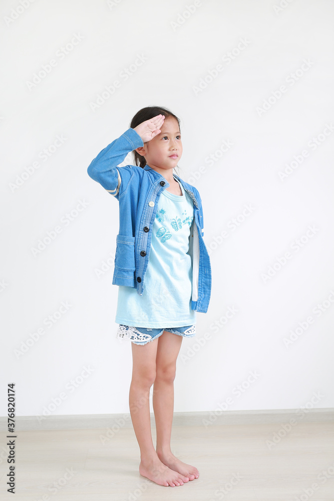 Portrait of asian little child girl saluting with hand at forehead indoor. Full-length. Portrait of asian little child girl saluting with hand at forehead indoor. Full-length.