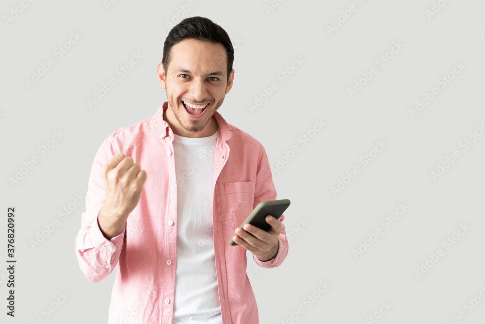 Latin man winning something with a smartphone Latin man winning something with a smartphone