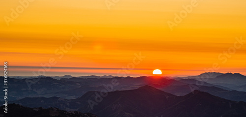 Na zdjeciu widzimy spektakularny wschód słońca ze szczytu góry w paśmie górskim w środkowych Włoszech.