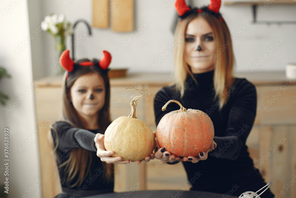 Fototapeta premium Halloween. Mother and daughter in halloween costume. Family at home.