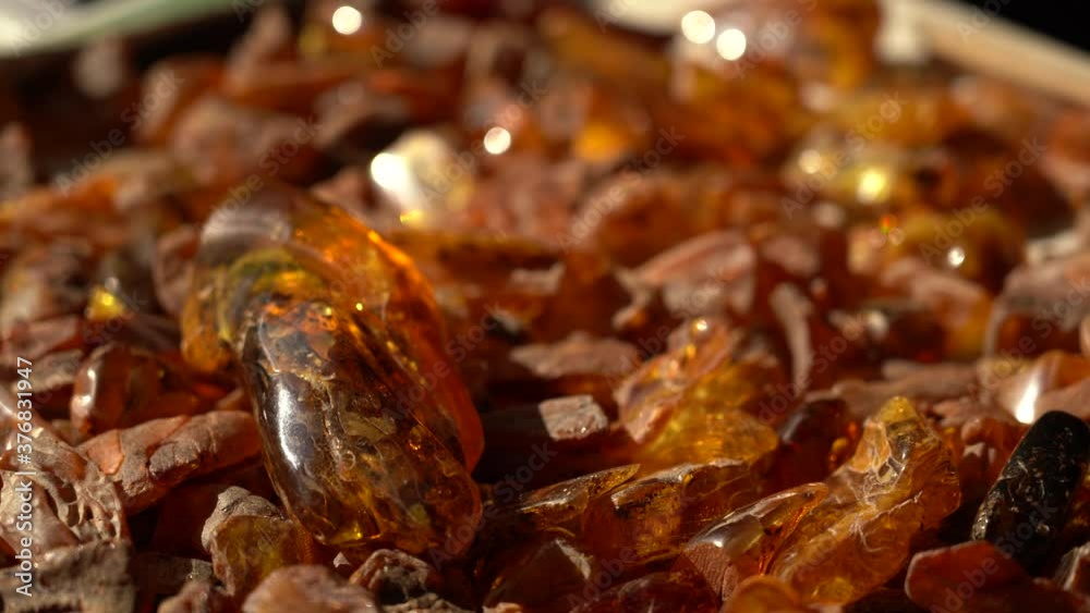 Handhel Shot of Unpolished Scattered Pieces of Amber with Rich Orange Colour Handhel Shot of Unpolished Scattered Pieces of Amber with Rich Orange Colour
