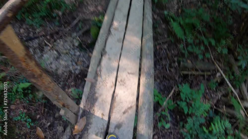 Hiking boots walk on wooden bridge in forest. Hiking boots walk on wooden bridge in forest.