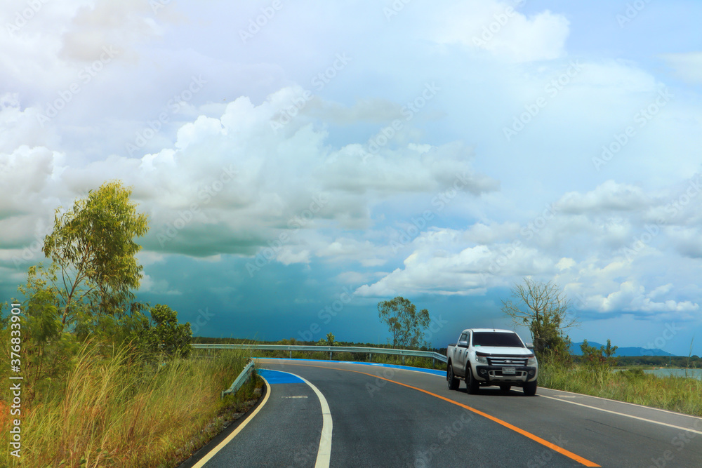 A white car running on a spring road among the mountains. A white car running on a spring road among the mountains.