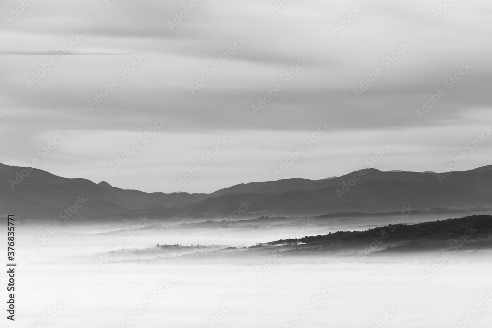 Fog filling a valley in Umbria (Italy), with layers of mountains and hills