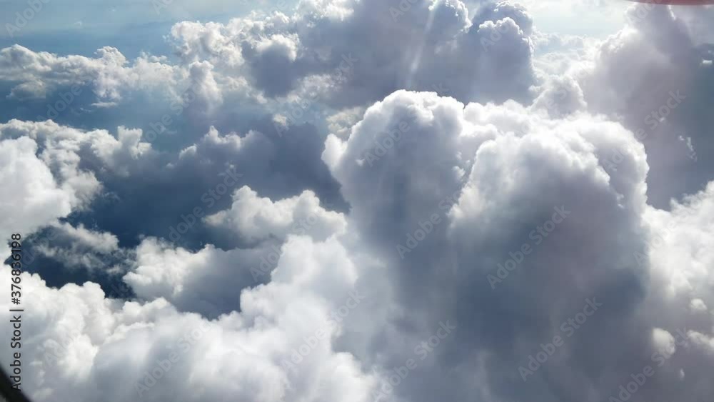 fliyng fast trough some thick white clouds, view from airplane window