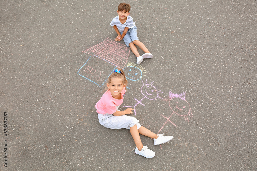 Naklejka premium Little children drawing with chalk on asphalt