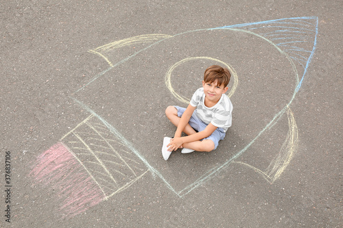 Little boy sitting on chalk...