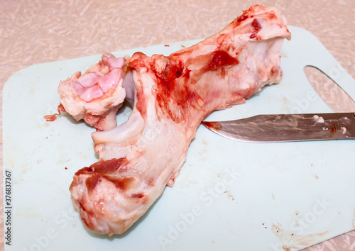 Raw pork bone on a chopping Board with a knife.