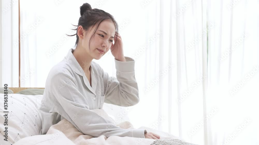 パジャマ姿の若い女性 頭痛 パジャマ姿の若い女性 頭痛