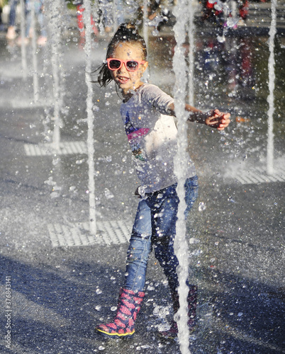 Little girl jumping in fountain