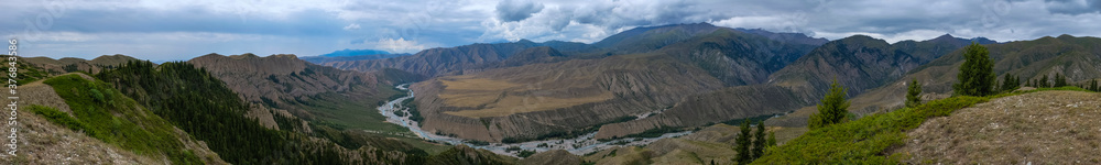 Panoramic view of moutain river valley with sky background. Beautiful wild nature landscape. Adventure travel. Outdoor landscape. Usek river valley in Kazakhstan. Tourism in Kazakhstan concept.
