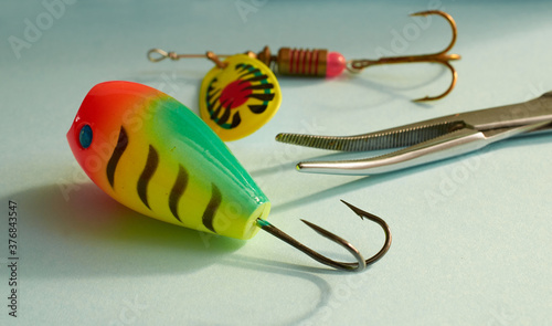 Fishing equipment. Two multi-colored fishing lure and scissors to extract the hook close-up