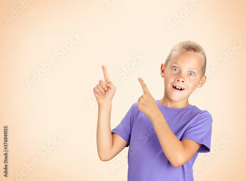 Funny surprised boy pointing with hand and finger
