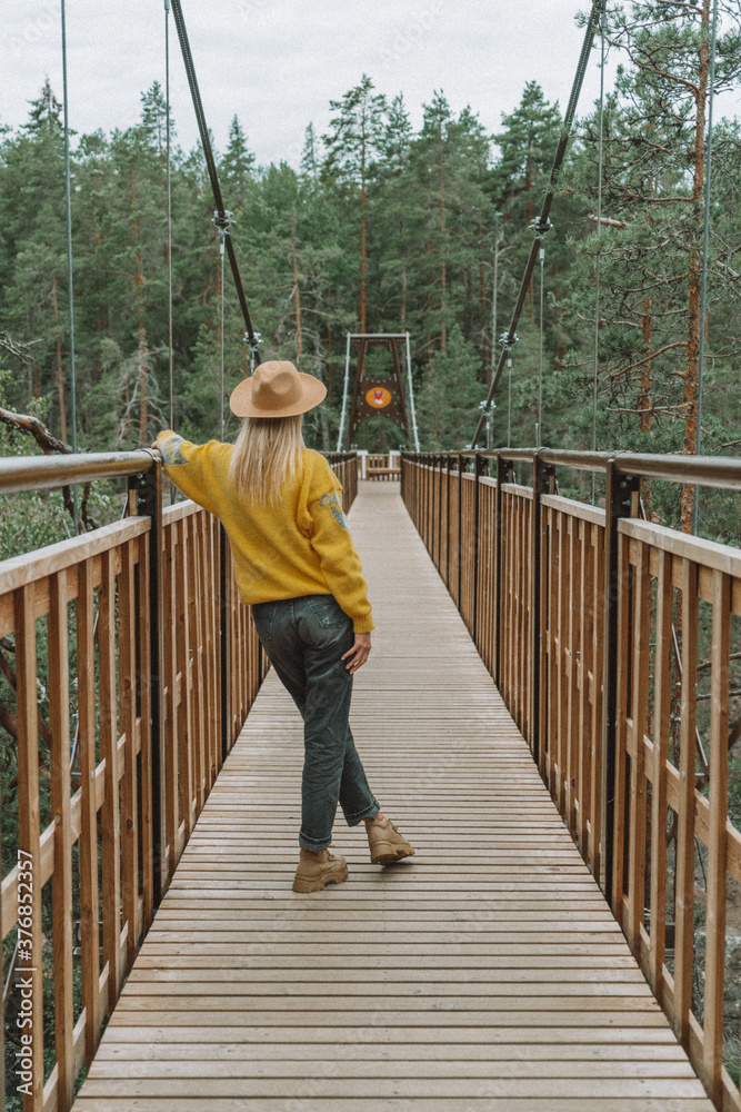 Women girl standing on the wooden bridge in Finland national park