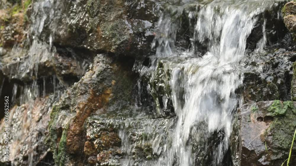 The small cascade waterfall. Up-close shot of water trickling over rocks. The small cascade waterfall. Up-close shot of water trickling over rocks.
