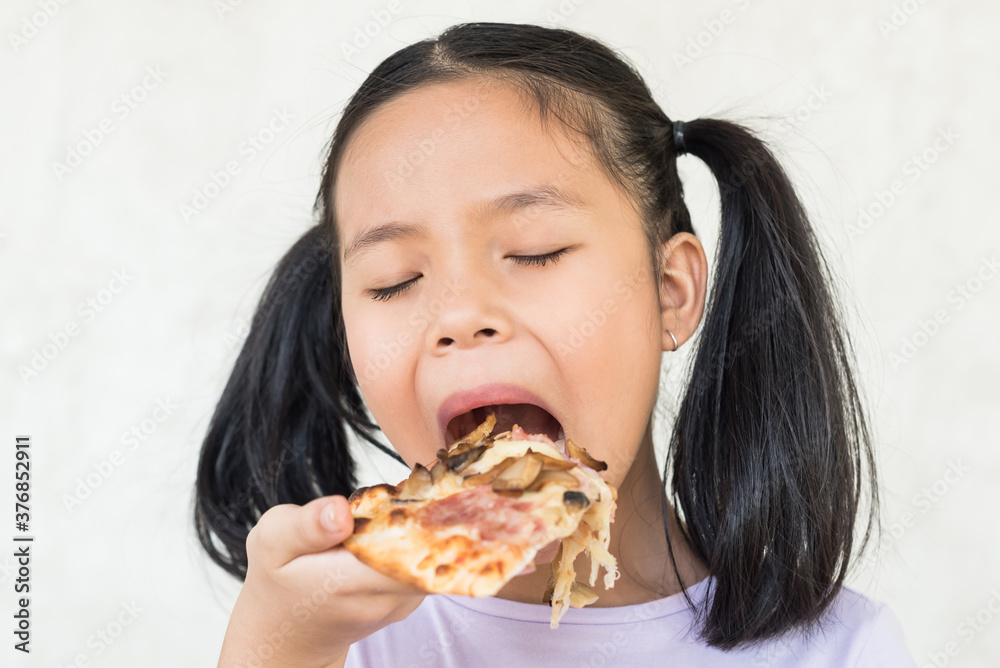 cute little girl holds piece of pizza, hungry student opens mouth wide while sees delicious slice of pizza, wants to eat, positive woman with junk food, people and eating, people and snack concept. cute little girl holds piece of pizza, hungry student opens mouth wide while sees delicious slice of pizza, wants to eat, positive woman with junk food, people and eating, people and snack concept.