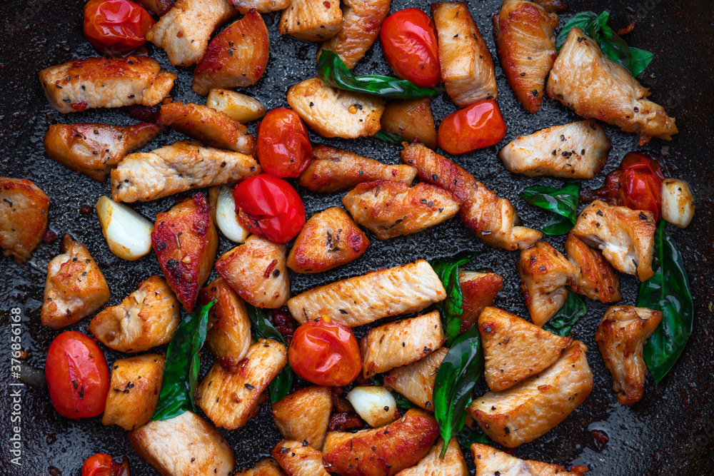 Frying pan with hot Italian food isolated on white background. Healthy chicken meat, tomatoes and herbs
