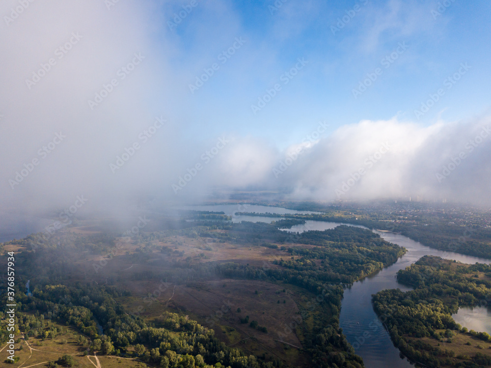 Flight among thick clouds over the Dnieper river in Kiev. Flight among thick clouds over the Dnieper river in Kiev.